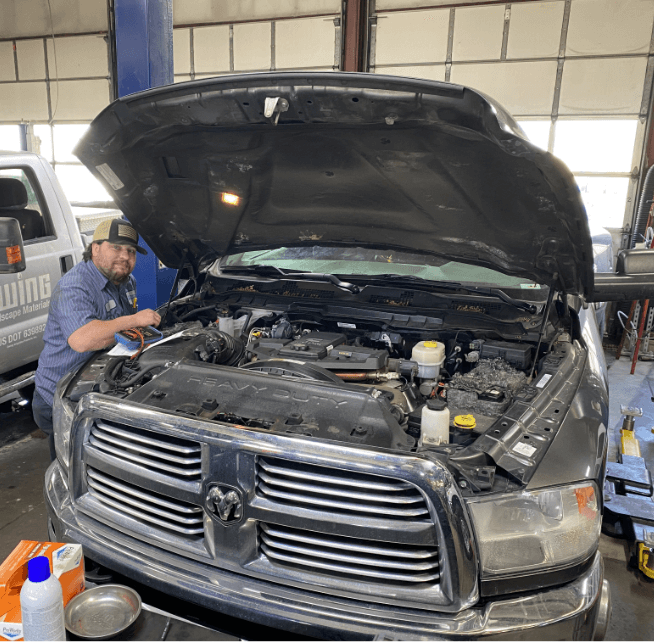 Concept of Branch Automotive's services, including diesel repair and digital vehicle inspection. Image of a Branch Automotive mechanic working on a diesel vehicle.