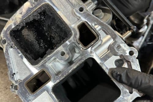 Expert Tips for Diesel Owners: Dealing with a Clogged EGR Cooler | Branch Automotive. Image of clogged egr cooler on 6.7 powerstroke in shop.