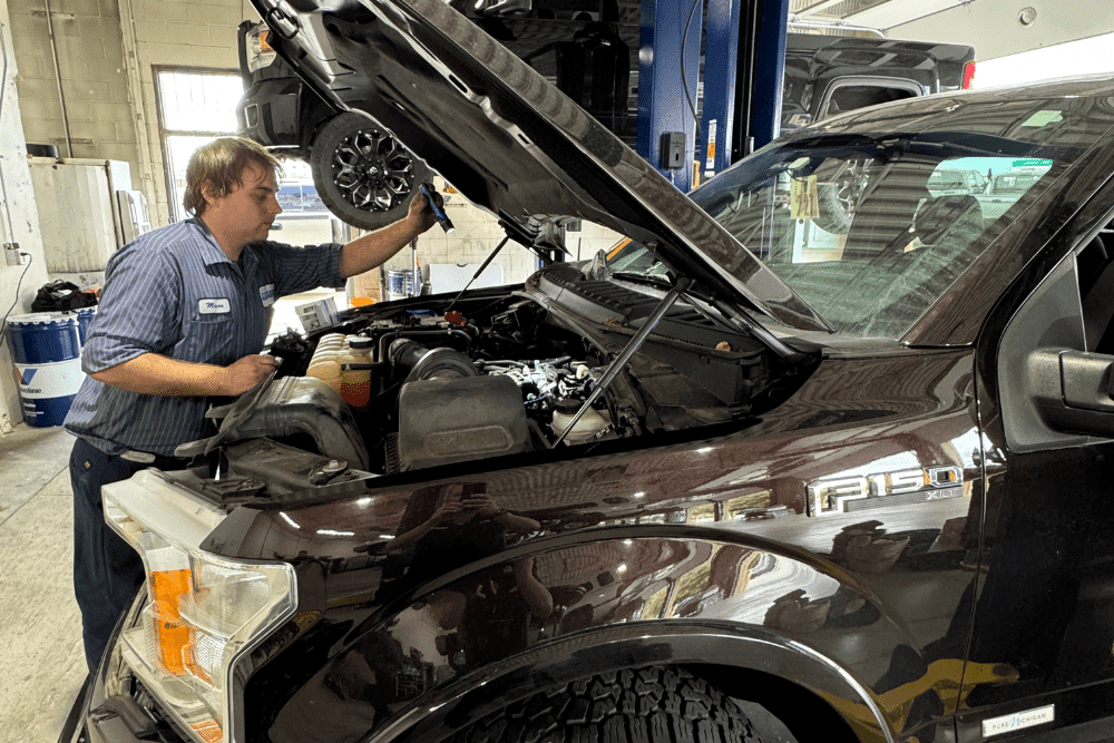ford ecoboost engine repair, diesel repair in Littleton, CO at Branch Automotive. A technician performing an engine check on a Ford F-150 inside an auto repair shop.