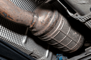 DPF failure, diesel repair in Littleton, CO by Branch Automotive. Close-up image of a DPF unit under a vehicle, illustrating professional diesel exhaust system maintenance and emissions repair for Ford Powerstroke, Duramax, and Cummins trucks.