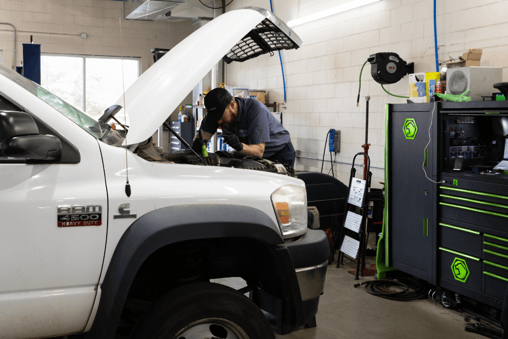 Diesel repair near Elizabeth, CO by Branch Automotive. Image of a technician performing engine service on a RAM 3500 heavy-duty pickup inside a professional repair shop, highlighting skilled diesel diagnostics, maintenance, and dependable service for work trucks.