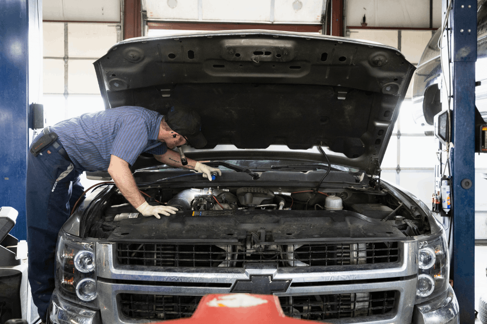 Diesel repair near Highlands Ranch, CO by Branch Automotive. Image of a technician inspecting the engine bay of a Chevrolet heavy-duty pickup, highlighting professional diesel troubleshooting, maintenance, and dependable service for work trucks and towing vehicles.